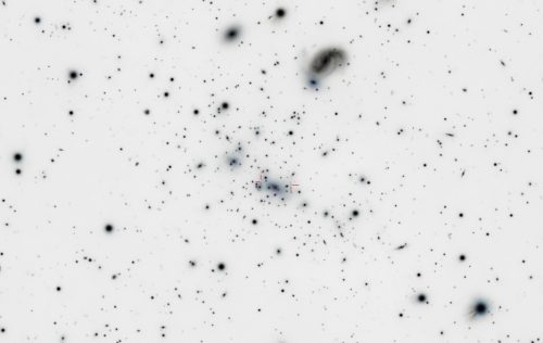 Negative of a photograph of gravitational lensing in the Abell 2218 galaxy cluster. The image was taken during testing at Astronomy Camp.